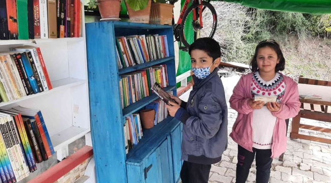 Evin bahçesine kurduğu kütüphanede mahallece kitap okuyorlar